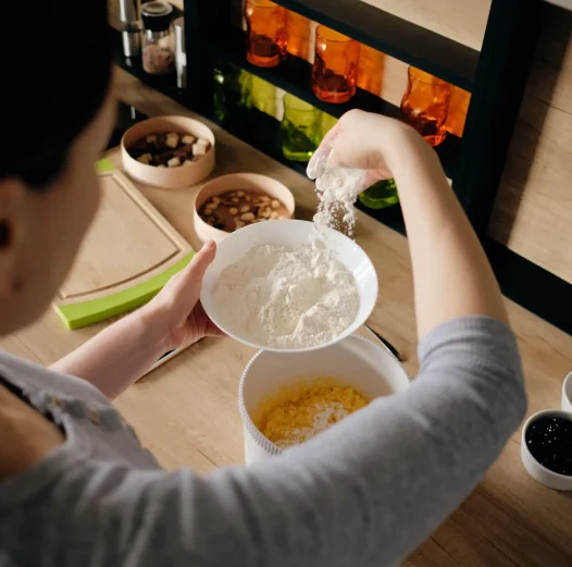 woman_hand_sprinkling_flour_in_white_bowl